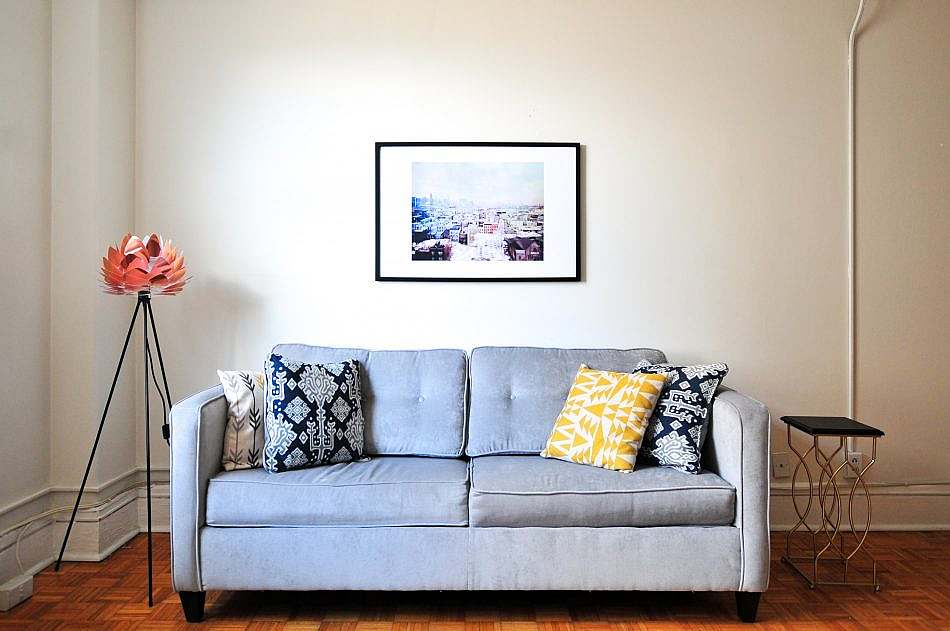 Komfortabel sofa med dekorative puder og et maleri på væggen