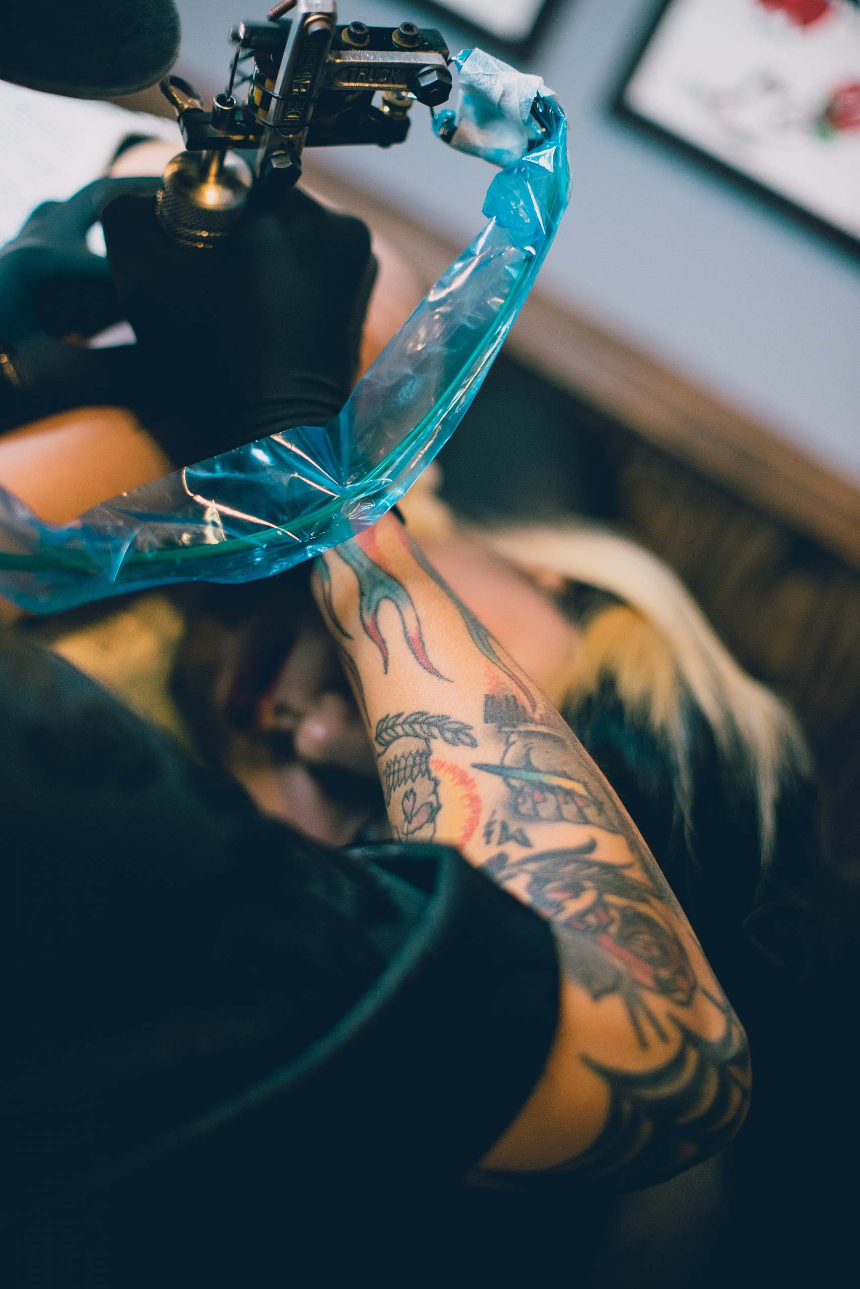 Tatovør der tatoverer med tatoveringsmaskine på klient