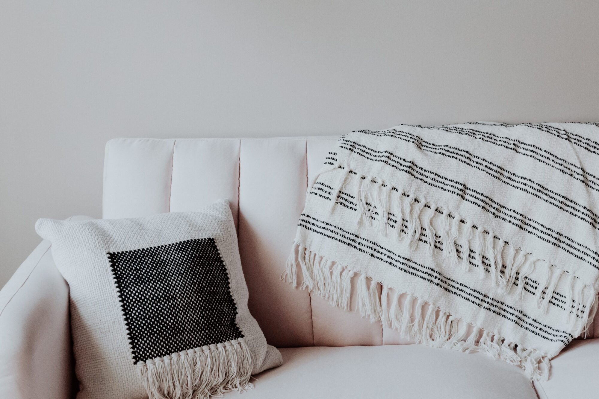 Komfortabel sofa med tæppe og dekorativ pude